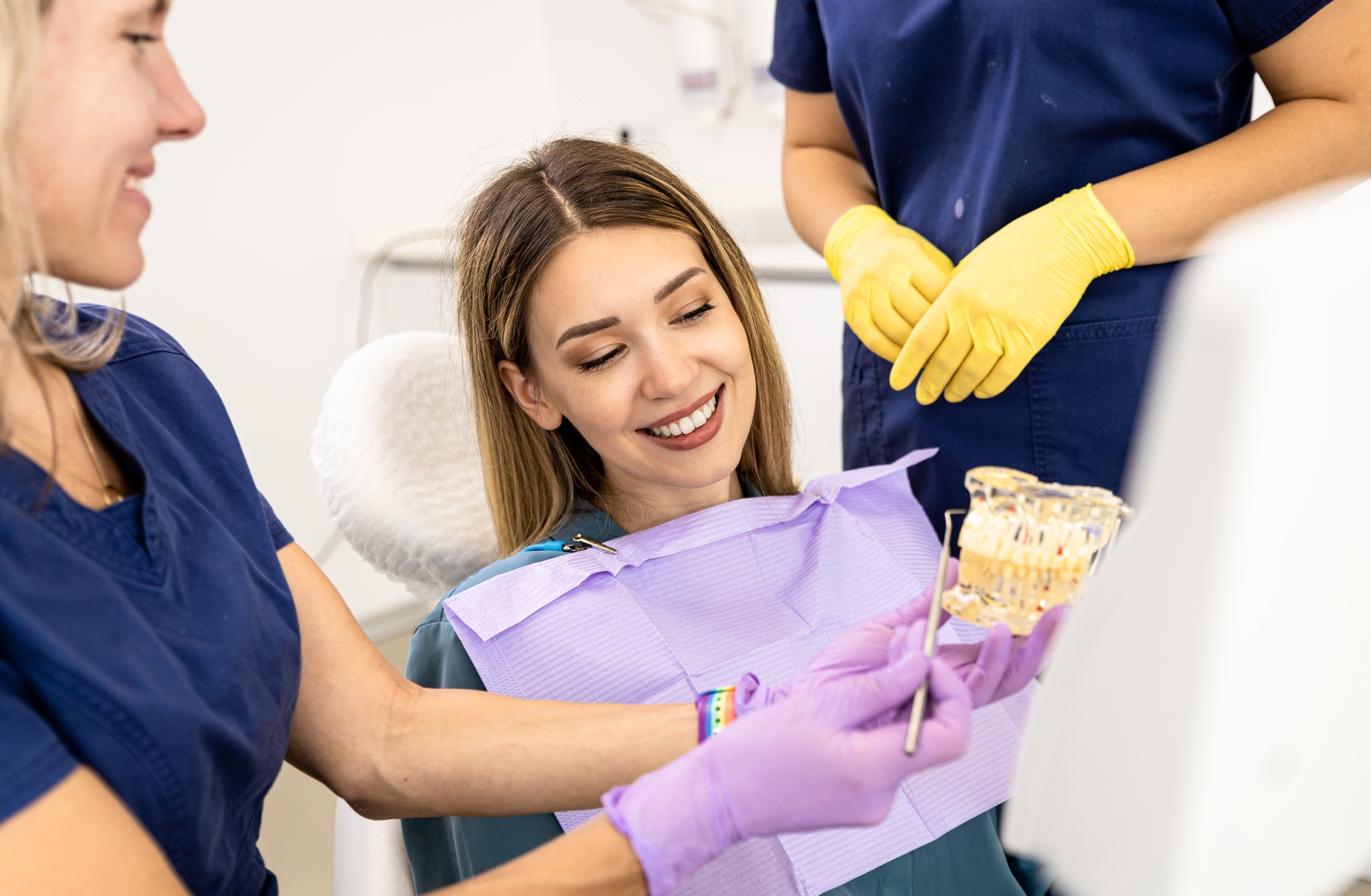 Female dentist takling with patient showing theet implant in dental clinic.